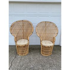 two wicker chairs sitting next to each other in front of a garage door,