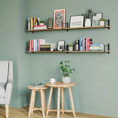 two wooden tables sitting next to each other in front of a wall with books on it