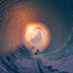 a man riding a wave in the middle of a tunnel