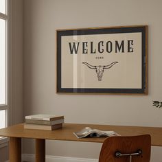 a wooden table sitting under a framed welcome sign