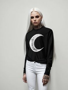 "Illuminate your style with the celestial elegance of \"Moon\" by Sorcere. Embrace the magic of the night sky in every step, and make a bold statement that sets you apart. Trust in the quality, indulge in the comfort, and let Sorcere redefine your wardrobe with this celestial-inspired black hooded long sleeve top. Designed with meticulous attention to detail, the white crescent moon on the black canvas creates a mesmerising contrast, capturing the essence of the night sky in a wearable form. This celestial touch brings an element of mystery and sophistication to your casual ensemble. Sorcere takes pride in sustainability and ethical practices. The \"Moon\" tee is crafted on demand, ensuring that each piece is created specifically for you. This approach not only reduces waste but also guara Black Long Sleeve Top With Moon Print, Fitted Black Tops With Moon Print, Fitted Moon Print Crew Neck Top, Black Celestial Crew Neck Top, Witch Core, Moon Fashion, Designer Top, Work Looks, Sustainable Clothing