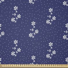 a blue background with white daisies and polka dots on it, as well as a ruler