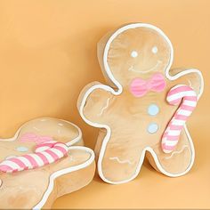 two gingerbread cookies with candy canes on them