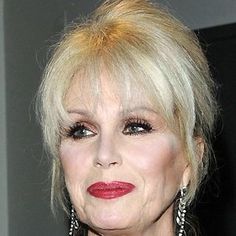 an older woman with blonde hair and red lipstick looks at the camera while wearing large earrings