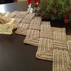 two crocheted placemats on a table next to a potted plant