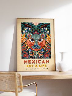 a mexican art and life poster hangs on the wall next to a desk with a chair