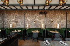 the interior of a restaurant with green velvet booths