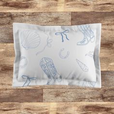 an image of a pillow on the floor with shells and seashells in blue ink