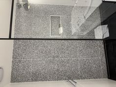 a bathroom with black and white speckles on the wall