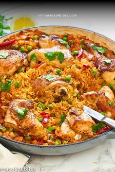 a pan filled with chicken and rice on top of a table