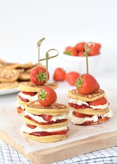 strawberry shortcakes stacked on top of each other with strawberries in the background