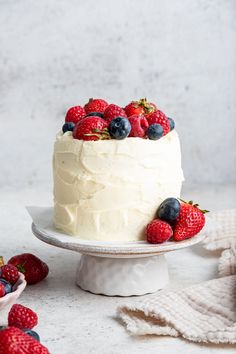 a cake with white frosting and fresh berries on top