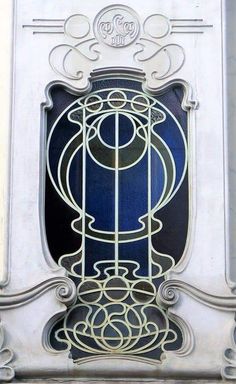 an art deco window on the side of a building with decorative ironwork around it