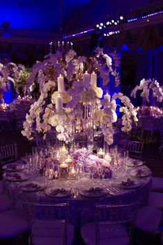 the table is set with candles, flowers and other decorations for an elegant wedding reception