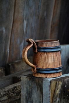 a wooden mug sitting on top of a piece of wood