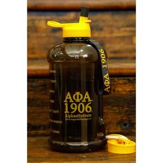 a water bottle sitting on top of a wooden table next to a yellow cup and lid