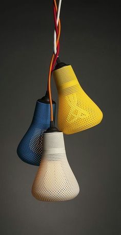 three different colored lamps hanging from wires