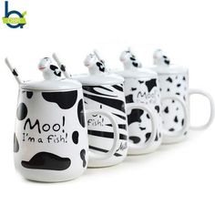 four coffee mugs with black and white designs on them that say moo, i'm a fish