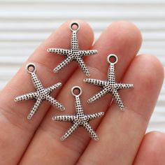 Silver starfish charm, starfish, sea charms, star charm silver, hammered beads, earring charms dangle, star, metal silver sea beads 18 mm edge to edge ( H: 21 mm with the top loop) Do you want to see more of sea findings? Just click the link below: https://www.etsy.com/shop/EastVillageSupply?ref=hdr_shop_menu&search_query=sea More of star findings? Please click the link below: https://www.etsy.com/shop/EastVillageSupply?ref=hdr_shop_menu&search_query=star -Actual colors of any item or na Sea Charms, Sea Beads, Silver Sea, Earring Charms, Dangle Charms, Star Charms, Matte Gold, Charm Earrings, Spacer Beads