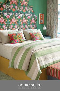 a bedroom with green walls and colorful bedding