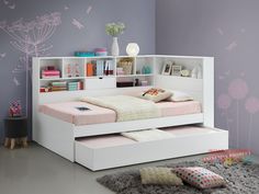 a bedroom with a bed, bookshelf and pink flowers on the wall behind it