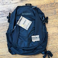 a back pack sitting on top of a wooden floor next to a pair of scissors