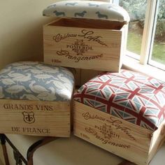 four wooden boxes sitting on top of a table next to a window with the words grand vins written on them