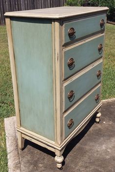 an old dresser is painted blue and has brass knobs