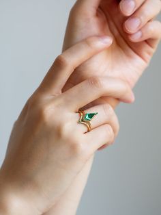 Why You'll Love It This alternative and geometric inspired ring displays a stunning kite emerald. The center stone is encased in a one-of-a-kind setting with a minimal band and bright petite diamonds to emphasis its beauty! Details 14K solid gold Band width is approx. 1.60mm Lab-grown Emerald x 1 piece (approx. 1ct) 1.5mm Round Natural Emerald x 2 pieces SI/G Color White 1mm Round diamond x 12 pieces Complementary Pieces Lucy Band (Emerald) Calista Band Lillie Band Design Your Own Modern Emerald-cut Green Diamond Ring, Modern Green Emerald Ring With Accent Stones, Modern Green Diamond Promise Ring, Modern Green Diamond Wedding Ring, Modern Emerald Gemstone Ring For Wedding, Modern Emerald Ring With Diamond Accent Stones, Modern Diamond Ring For May Birthstone, Modern Emerald Ring For Wedding, Modern May Birthstone Diamond Ring