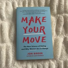 the book make your move by jon bigger is laying on a bed with white sheets