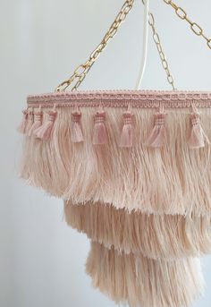 a pink chandelier with tassels hanging from it