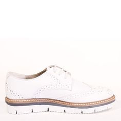 a white shoe with brown soles on a white background and no one is wearing it