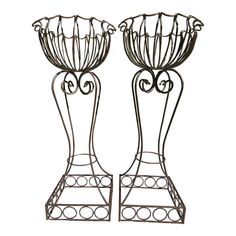 two metal vases sitting next to each other on top of a white background,