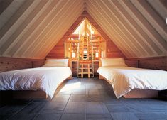 two beds in a room with wooden walls and beams on the ceiling are made of wood