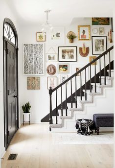 an entryway with stairs and pictures on the wall