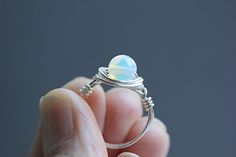 Beautiful dainty ring features a small  6 mm Opalite gemstone set in Non-tarnish silver, Sterling silver, Rose gold, Black, Copper or Gold plated wire. Opalite is a man made variety of glass. Opalite is believed to alleviate depression, soothe frayed nerves and help us to step away from anxiety. It is said to bring inner peace and a sense of calm in any situation. For this ring I have used a slightly thinner wire to make it look delicate on your finger. SIZING: All rings are made to size as sele Opalite Earrings, Opalite Jewelry, Ring Crystal, Tarnished Silver, Wire Ring, Citrine Stone, Wire Rings, Chip Beads, Ring Boho