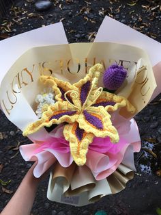 a crocheted flower is held by someone's hand