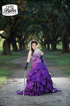 a woman in a purple dress holding a stick