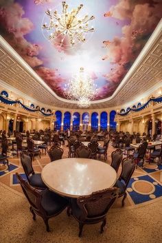 the dining room is decorated in blue and white with chandeliers hanging from the ceiling