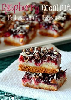 raspberry coconut magic bars stacked on top of each other in front of a plate