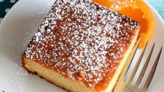 a piece of cake sitting on top of a white plate next to an orange slice