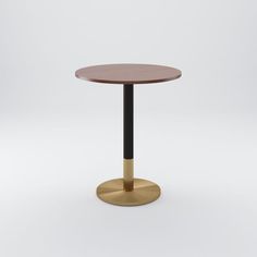 a round wooden table with a black metal base and a gold plated steel top