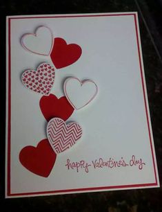 valentine's day card with red and white heart cutouts on the front, sitting on a table