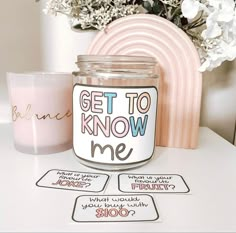 a candle and some stickers sitting on a table next to a vase with flowers