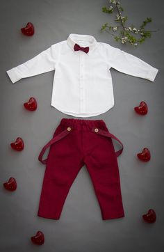 a white shirt and red pants with hearts on the floor next to it are two pieces of clothing