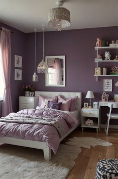 a bedroom decorated in purple and white with a bed, desk, chair, window and rug