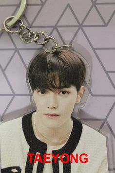 a key chain with an image of taehyng on it