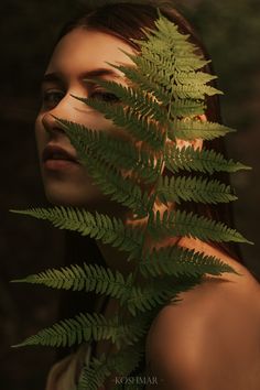 a woman with long hair holding a green plant