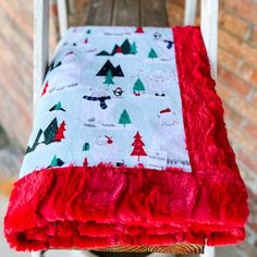 a red and white blanket sitting on top of a wooden chair