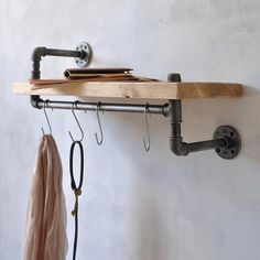 a coat rack with two hooks and some clothes hanging on the wall next to it